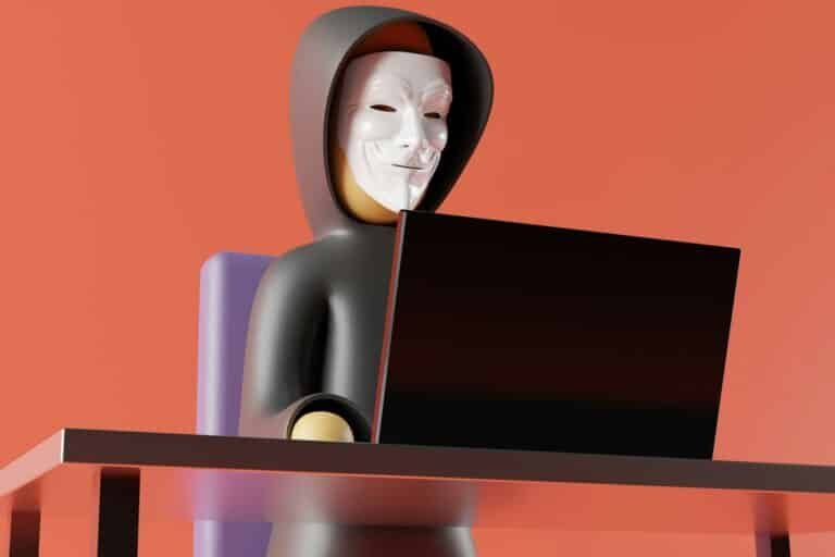 Figura con máscara frente a un computador, representación de la suplantación de identidad