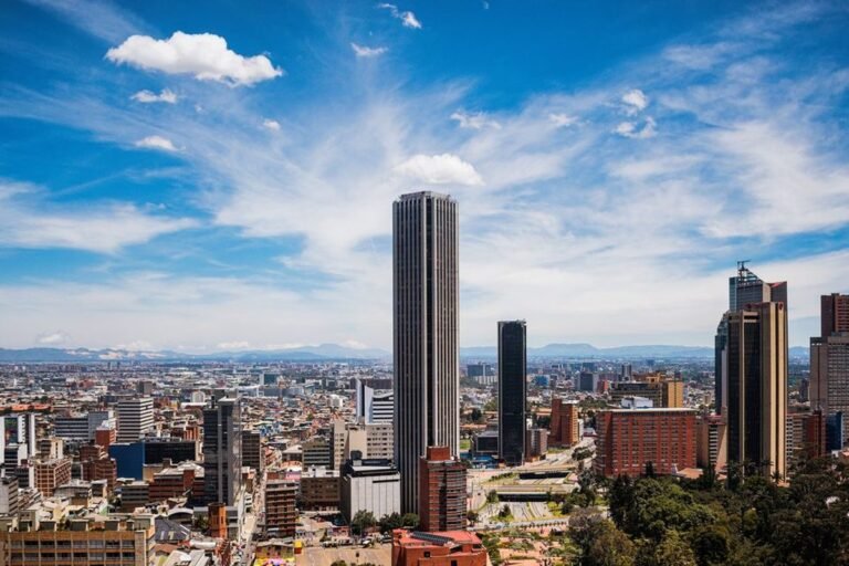 Vista de edificios altos del centro de Bogotá bajo un cielo azul con nubes